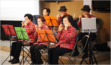노인들이 하모니카를 연주하고 있는 모습입니다.